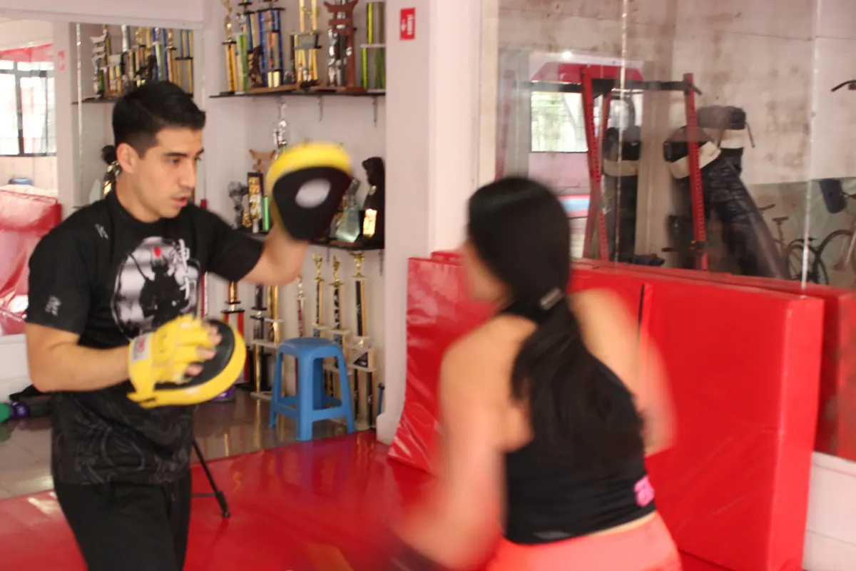 Alumna golpeando manoplas con su entrenador en Fitness Training, Narvarte