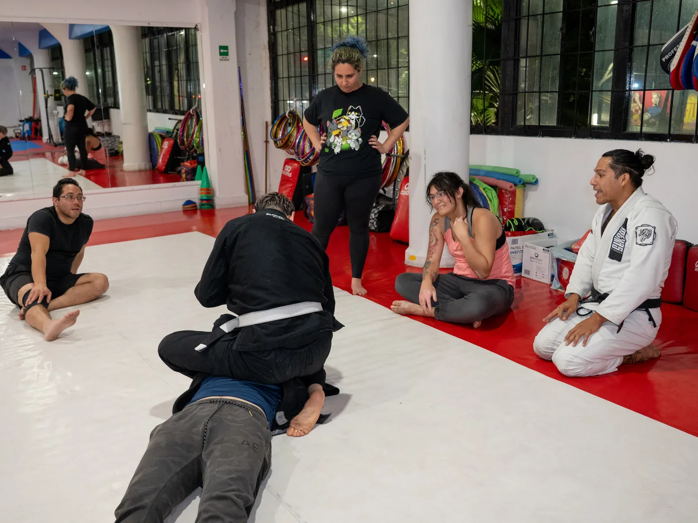 Grupo diverso de alumnos y alumnas conversando después de clase de Jiu-Jitsu en Sharks Academy